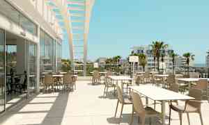 Ulkona sijaitseva ravintolatila, jossa pöytiä ja tuoleja, avoimen rakenteen alla, näkymänä palmuja ja rakennuksia. (Tekoälyn luoma teksti)