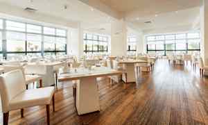 Moderni ja valoisa ravintola, jossa on suuret ikkunat ja katetut pöydät. (Tekoälyn luoma teksti)