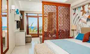 Hotellihuone, jossa vuode, koristeellinen puupaneeli ja merinäköala. (Tekoälyn luoma teksti)