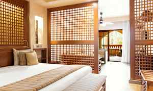 Hyvin kalustettu makuuhuone, jossa on koristeelliset puupaneelit, jotka erottavat olohuoneen. (Tekoälyn luoma teksti)