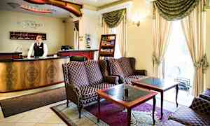 Hotellin vastaanotto, jossa on istuinryhmä ja koristeellisia huonekaluja. (Tekoälyn luoma teksti)