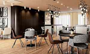 Moderni ja kutsuva kahvila, jossa on tuoleja ja pöytiä tyylikkäässä sisustuksessa. (Tekoälyn luoma teksti)