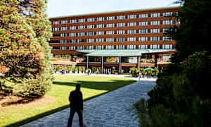 Rakennus, jossa on moderni sisäänkäynti, ympäröitynä vehreydellä ja käytävillä. (Tekoälyn luoma teksti)