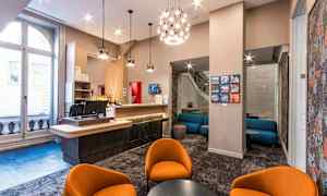 Aula, jossa istuinryhmä, tuoleja ja baarituoleja modernissa sisustuksessa. (Tekoälyn luoma teksti)