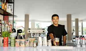 Baaritiski, jossa on erilaisia pulloja, välineitä ja tarjoilutarvikkeita. (Tekoälyn luoma teksti)