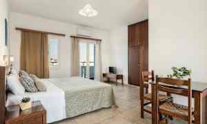 Makuuhuone, jossa on parivuode, pieni pöytä ja kaksi tuolia sekä vaatekaappi. (Tekoälyn luoma teksti)