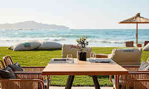 Pöytä ja tuolit terassilla, näkymä merelle. (Tekoälyn luoma teksti)