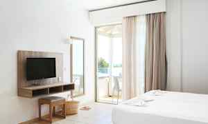 Hotellihuone, jossa on kaksi vuodetta, televisio, peili ja parveke. (Tekoälyn luoma teksti)