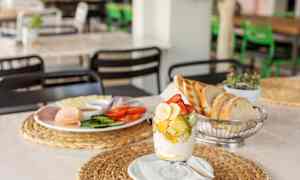 Aamiainen, jossa on tuoretta hedelmää lasissa, leipää ja leikkeleitä lautasella. (Tekoälyn luoma teksti)