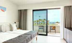 Hotellihuone, jossa on pedattu vuode ja näkymä palmuihin ja merelle. (Tekoälyn luoma teksti)