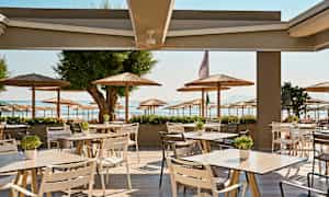 Ulkoterassi, jolta näkyy rantaan ja aurinkovarjoihin. (Tekoälyn luoma teksti)