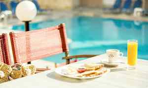 Aamiaistarjotin mehulla ja kahvilla pöydällä uima-altaan vieressä. (Tekoälyn luoma teksti)