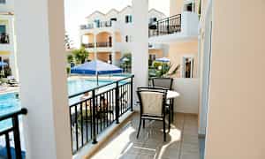 Parveke, jossa on kalusteet, näkymä altaalle ja oransseja rakennuksia. (Tekoälyn luoma teksti)