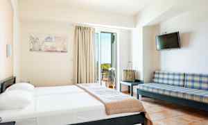 Hotellihuone, jossa on sänky, sohva, televisio ja parveke. (Tekoälyn luoma teksti)