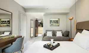 Hotellihuone, jossa sänky, sohva ja kirjoituspöytä. (Tekoälyn luoma teksti)