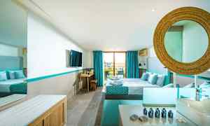 Moderni hotellihuone, jossa on parivuode, sinisiä yksityiskohtia ja suuri ikkuna parvekkeelle. (Tekoälyn luoma teksti)