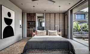 Moderni makuuhuone, jossa suuri sänky ja avoin lasiseinä avautuu terassille. (Tekoälyn luoma teksti)