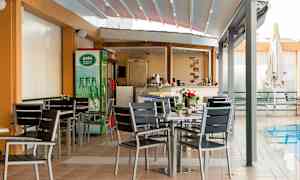 Ulkoterassi, jossa on pöytiä ja tuoleja uima-altaan vieressä. (Tekoälyn luoma teksti)