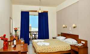 Hotellihuone, jossa on parivuode ja kirjoituspöytä kukka-asetelmalla. (Tekoälyn luoma teksti)