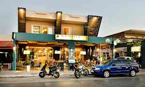 Akatos-hotellin julkisivu, jonka edessä on autoja ja moottoripyöriä. (Tekoälyn luoma teksti)