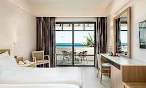 Hotellihuone, jossa on sänky, kirjoituspöytä ja parveke merinäköalalla. (Tekoälyn luoma teksti)