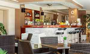 Baari, jossa korkeat tuolit ja pöydät edessä. (Tekoälyn luoma teksti)