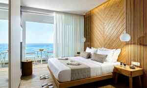 Hotellihuone merinäköalalla, iso sänky ja seinä puupaneeleilla. (Tekoälyn luoma teksti)