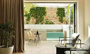 Moderni huone, jossa istuma-alue ja näkymä yksityiseen altaaseen ja seinään, jossa köynnöskasvi. (Tekoälyn luoma teksti)