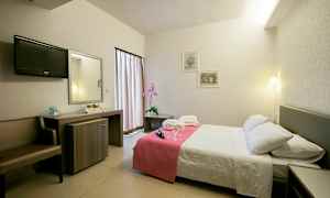 Hotellihuone, jossa on parivuode, yöpöytä ja kirjoituspöytä. (Tekoälyn luoma teksti)