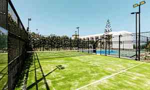 Ulkona sijaitseva valaistu padelkenttä, jonka keskellä on verkko. (Tekoälyn luoma teksti)