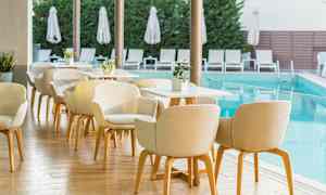 Ulkoterassi uima-altaan äärellä, jossa on tuoleja ja pöytiä. (Tekoälyn luoma teksti)