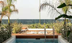 Pieni uima-allas viereisellä puutarha-alueella, näkymä merelle ja lasikaide. (Tekoälyn luoma teksti)