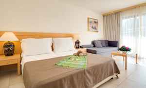 Hotellihuone, jossa parisänky, sohva ja pöytä. (Tekoälyn luoma teksti)