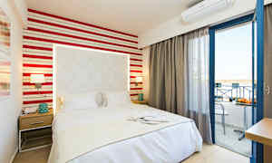 Hotellihuone, jossa sänky, yöpöytä ja avoin parvekkeen ovi. (Tekoälyn luoma teksti)