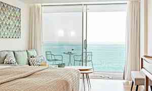 Makuuhuone, josta avautuu merinäkymä suurten lasiovien kautta, jotka johtavat parvekkeelle. (Tekoälyn luoma teksti)