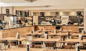 Ruokailutila, jossa puukalusteita ja tarjoilutiski taustalla. (Tekoälyn luoma teksti)