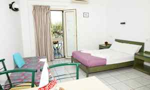 Hotellihuone, jossa on parisänky, sohva, pöytä tuoleineen ja parveke näkymällä. (Tekoälyn luoma teksti)