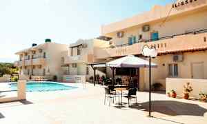 Hotellin ulkoalue, jossa uima-allas, aurinkovarjo ja istuinpaikkoja. (Tekoälyn luoma teksti)