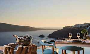 Katettu pöytä kahdelle istuimelle ja näkymä merelle ja ympäröiville saarille auringonlaskussa. (Tekoälyn luoma teksti)