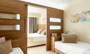 Hotellihuone jaettu design, jossa kaksi sänkyä ja puupaneeli, joka erottaa huoneet. (Tekoälyn luoma teksti)