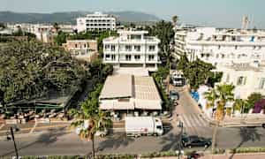 Ilmakuva kaupunkikadusta, jossa on rakennuksia, ravintola ja ajoneuvoja. (Tekoälyn luoma teksti)