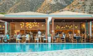 Ravintola altaan äärellä, taustalla vuoria. (Tekoälyn luoma teksti)