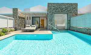 Huvila, jossa uima-allas ja aurinkotuoleja sisäänkäynnin luona. (Tekoälyn luoma teksti)