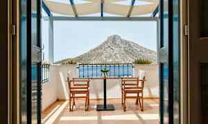 Näkymä terassilta, jossa on kaksi tuolia ja pöytä, taustalla näkyy vuori. (Tekoälyn luoma teksti)