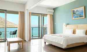 Hotellihuone, jossa on parivuode, lasiovet parvekkeelle ja merinäköala. (Tekoälyn luoma teksti)