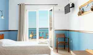 Hotellihuone, jossa kaksi sänkyä, näkymä parvekkeelle ja merelle. (Tekoälyn luoma teksti)