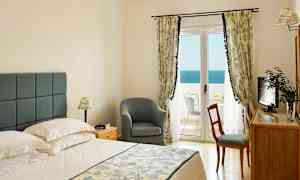 Makuuhuone, jossa on parivuode, tuoli, kirjoituspöytä ja parveke merinäköalalla. (Tekoälyn luoma teksti)