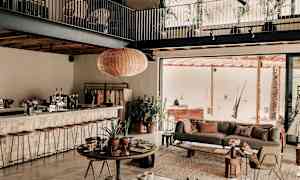 Modernin olohuoneen sisustus avoimella pohjaratkaisulla, sisältäen istuinkalusteita ja vihreitä kasveja. (Tekoälyn luoma teksti)