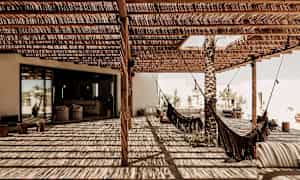 Katettu terassi, jossa riippumattoja ja varjoa puukatoksi. (Tekoälyn luoma teksti)