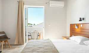 Hotellihuone, jossa on sänky ja parveke. (Tekoälyn luoma teksti)